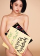 A naked woman holding a sign that says Bonita Applebum.