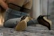 A woman sitting on the floor next to a pair of shoes.