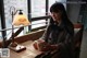 A woman sitting at a table with a cup of coffee.