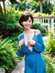 A woman in a blue dress posing for a picture.