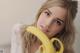 A woman holding a banana in front of her face.