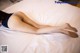 A woman laying on top of a white bed.