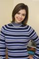 A woman in a blue and white striped sweater posing for a picture.