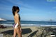 A woman in a bathing suit standing on a beach.