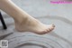 A close up of a woman's bare feet on a chair.